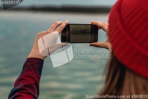 Image of Woman taking pictures with a cellphone