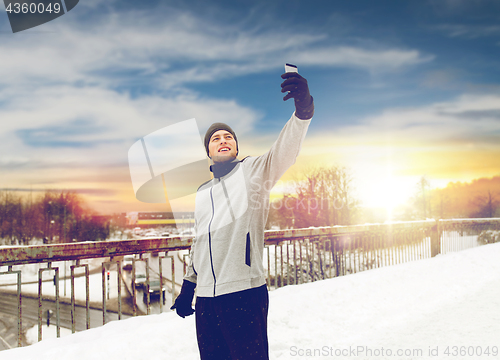 Image of man taking selfie with smartphone in winter 