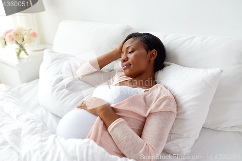 Image of pregnant african american woman sleeping at home