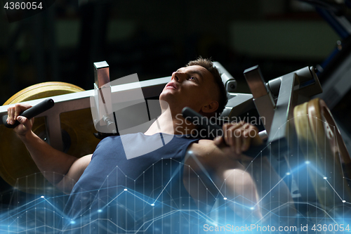 Image of man doing chest press on exercise machine in gym