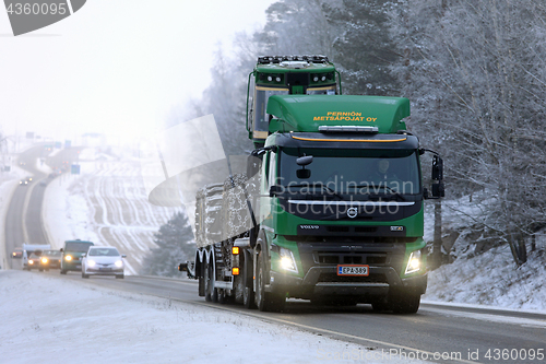 Image of Volvo FMX Hauls John Deere Forestry Machinery in Winter