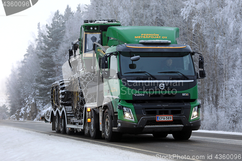 Image of Green Volvo FMX Truck Hauls John Deere Forestry Machinery