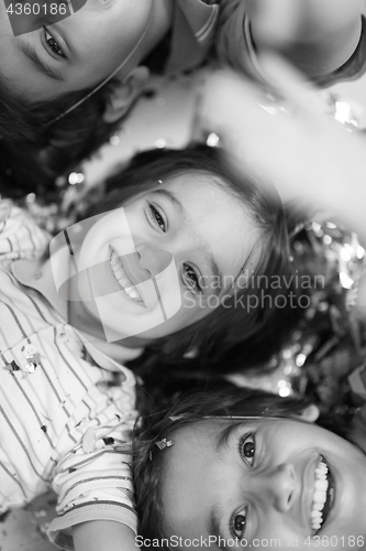 Image of kids  blowing confetti while lying on the floor