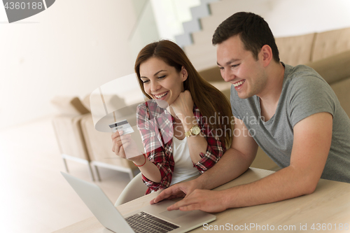 Image of happy young couple buying online