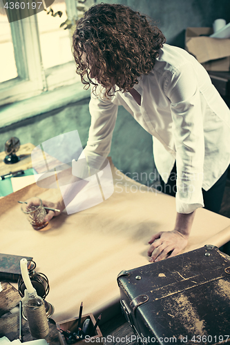 Image of Architect working on drawing table in office