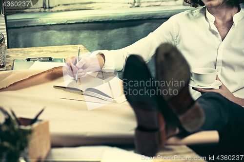 Image of Architect working on drawing table in office