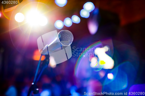 Image of Microphone on stage against a background of auditorium.