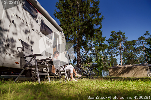 Image of Woman resting near motorhomes in nature. Family vacation travel,