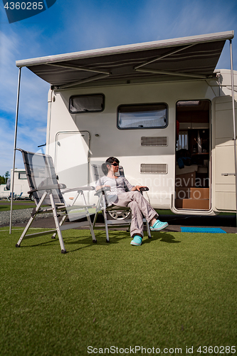 Image of Woman resting near motorhomes in nature. Family vacation travel,