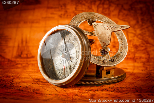 Image of Vintage compass lies on an ancient world map.