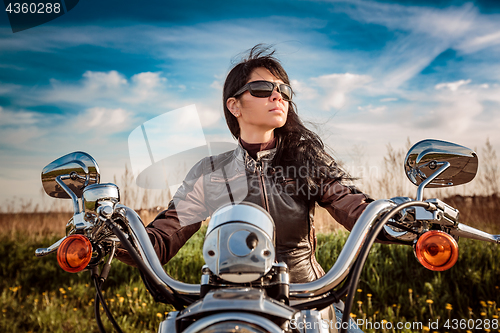 Image of Biker girl sitting on motorcycle