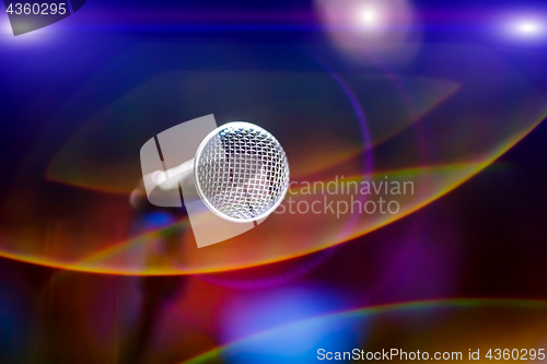 Image of Microphone on stage against a background of auditorium.