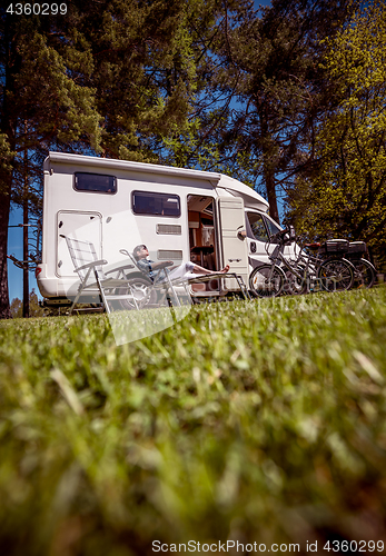 Image of Woman resting near motorhomes in nature. Family vacation travel,