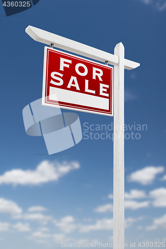 Image of Left Facing For Sale Real Estate Sign on a Blue Sky with Clouds.