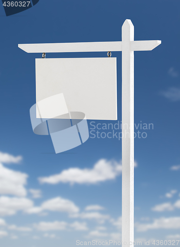 Image of Blank Real Estate Sign Over A Blue Sky with Clouds.