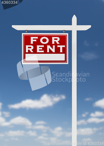 Image of Left Facing For Rent Real Estate Sign on a Blue Sky with Clouds.