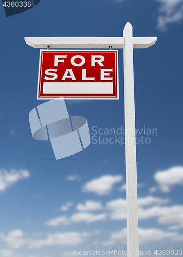 Image of Left Facing For Sale Real Estate Sign on a Blue Sky with Clouds.