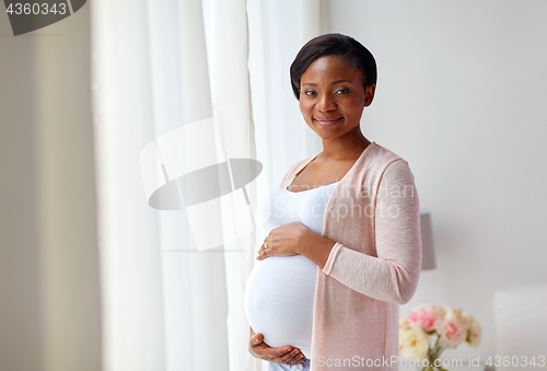 Image of pregnant african american woman at home window