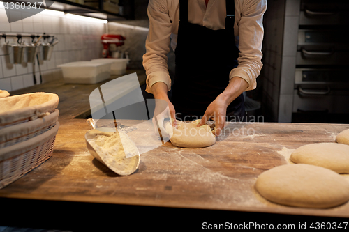 Image of baker portioning dough with bench cutter at bakery