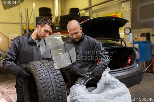 Image of auto mechanics changing car tires at workshop