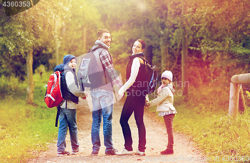 Image of happy family with backpacks hiking walking