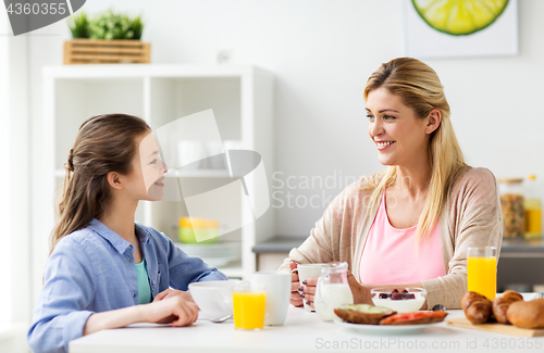 Image of happy family having breakfast at home kitchen