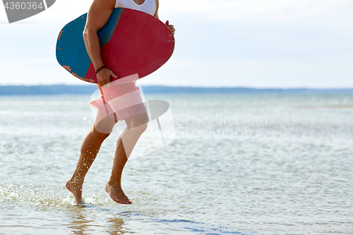 Image of young man with skimboard on summer beach