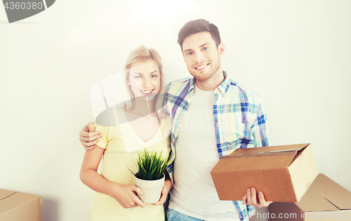 Image of smiling couple with big boxes moving to new home