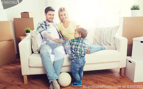 Image of happy family moving to new home and playing ball