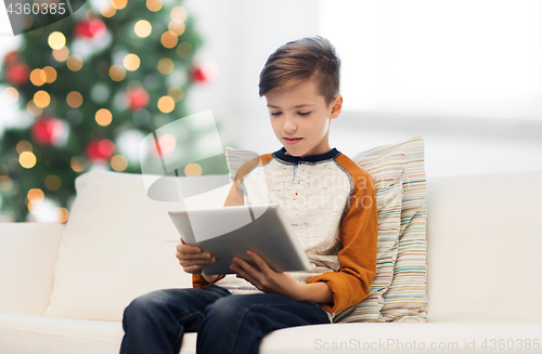 Image of boy with tablet pc at home at christmas