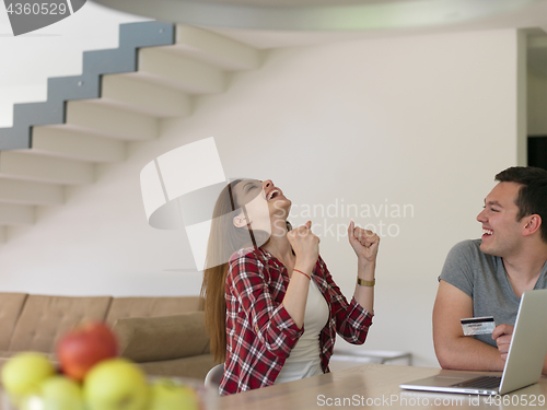 Image of happy young couple buying online