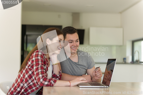 Image of happy young couple buying online