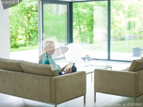Image of woman on sofa using tablet computer