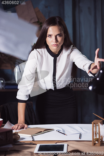 Image of Young business woman throwing documents at camera.