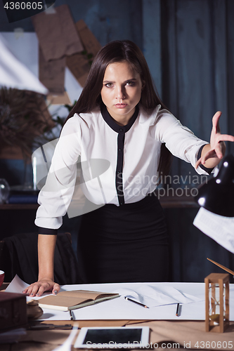 Image of Young business woman throwing documents at camera.