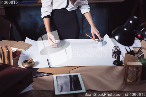 Image of Architect working on drawing table in office