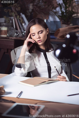 Image of Architect working on drawing table in office