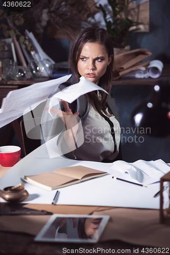 Image of Young business woman throwing documents at camera.