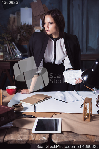 Image of Young business woman throwing documents at camera.