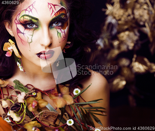 Image of beauty woman with face art and jewelry from flowers orchids close up
