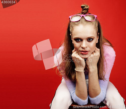 Image of young pretty teenage girl on bright red background, happy smilin