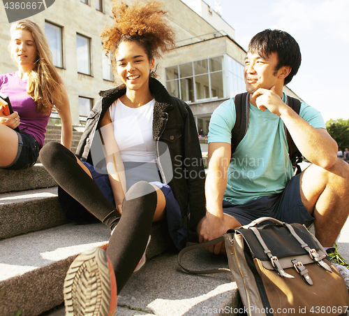 Image of cute group of teenages at the building of university with books huggings, back to school