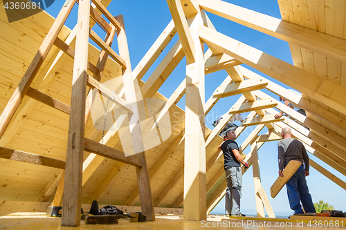 Image of Builders at work with wooden roof construction.