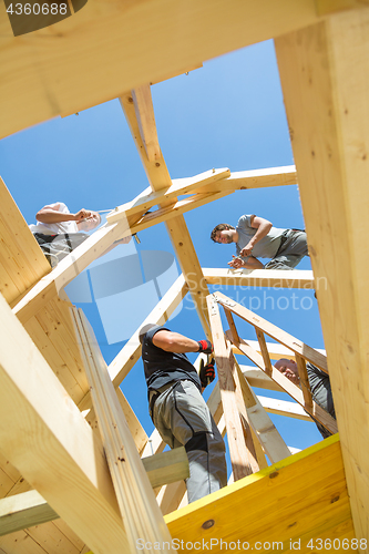 Image of Builders at work with wooden roof construction.