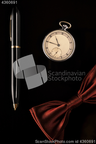 Image of Pocket watch, pen and bow-tie are men&#39;s accessories