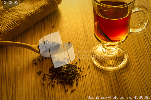 Image of Brewing tea, spoon with tea leaves and cup of tea