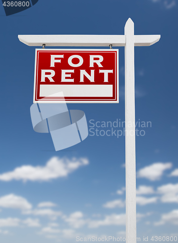 Image of Left Facing For Rent Real Estate Sign on a Blue Sky with Clouds.