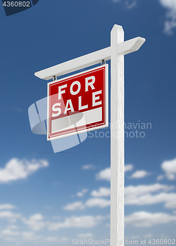 Image of Left Facing For Sale Real Estate Sign on a Blue Sky with Clouds.