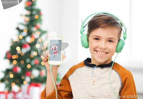 Image of boy with smartphone and headphones at christmas