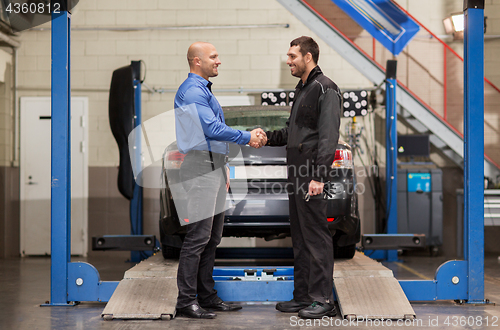 Image of mechanic and customer shaking hands at car service